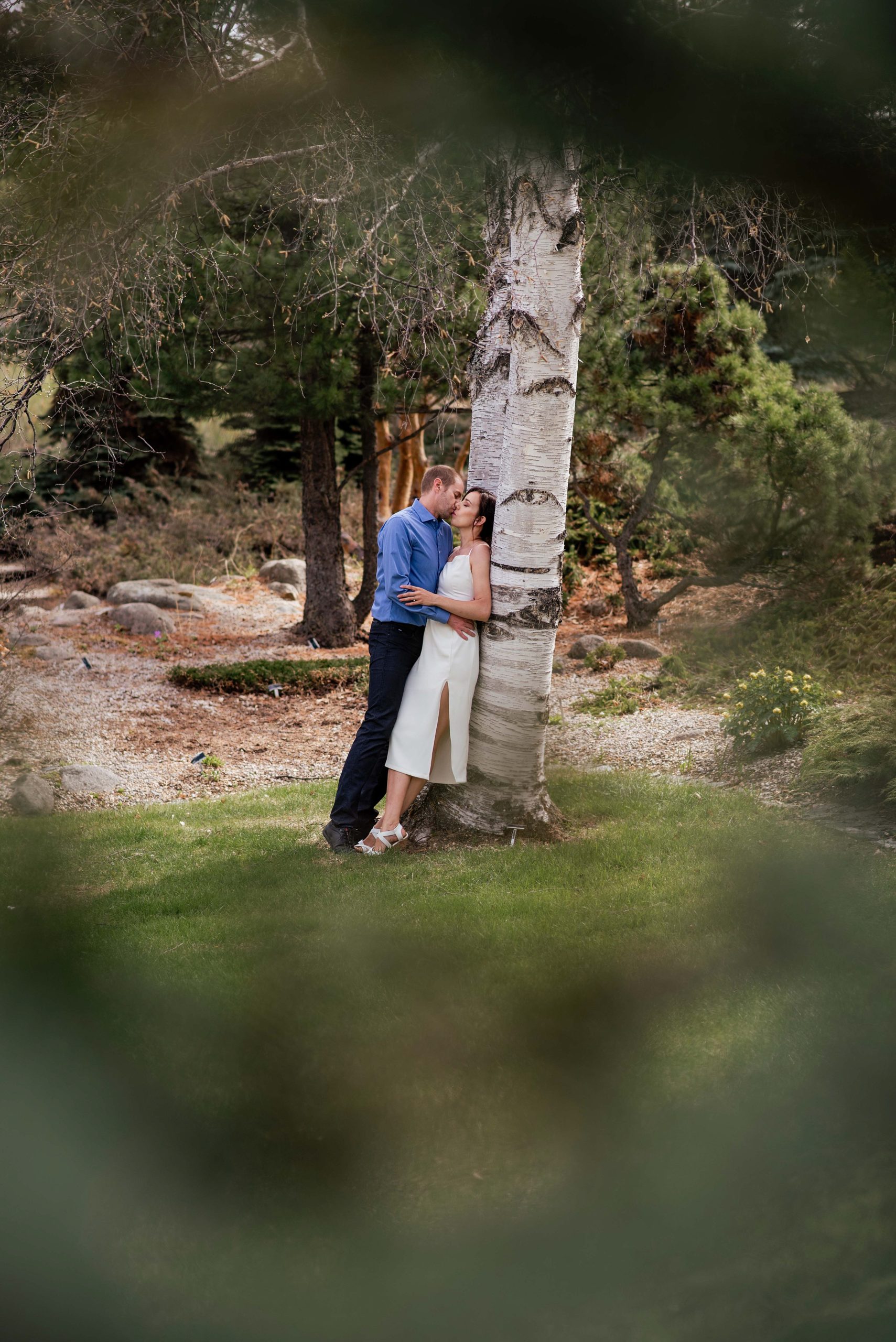 couple learning against a tree during their Edmonton engagement photography session